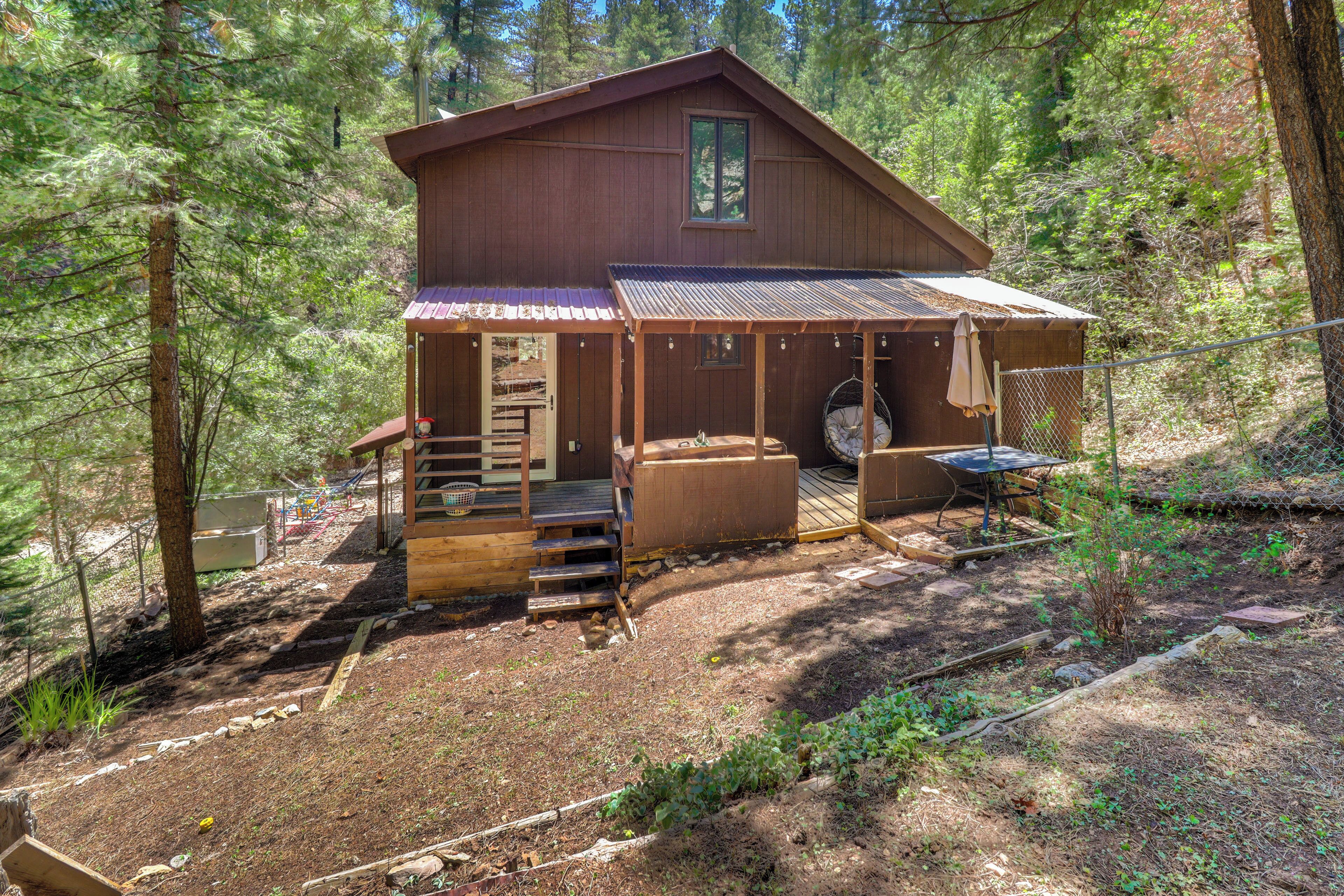 A cabin with a porch, outdoor seating, and a small deck.