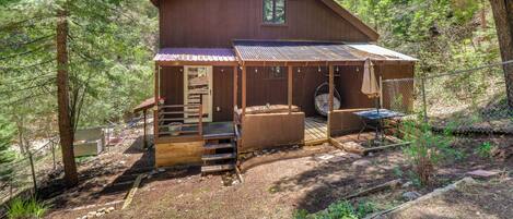 A cabin with a porch, outdoor seating, and a small deck.