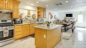 A spacious kitchen with wooden cabinets, granite countertops, and a central island. - Bay & Hill Views: Modern Hercules Home (Hercules)