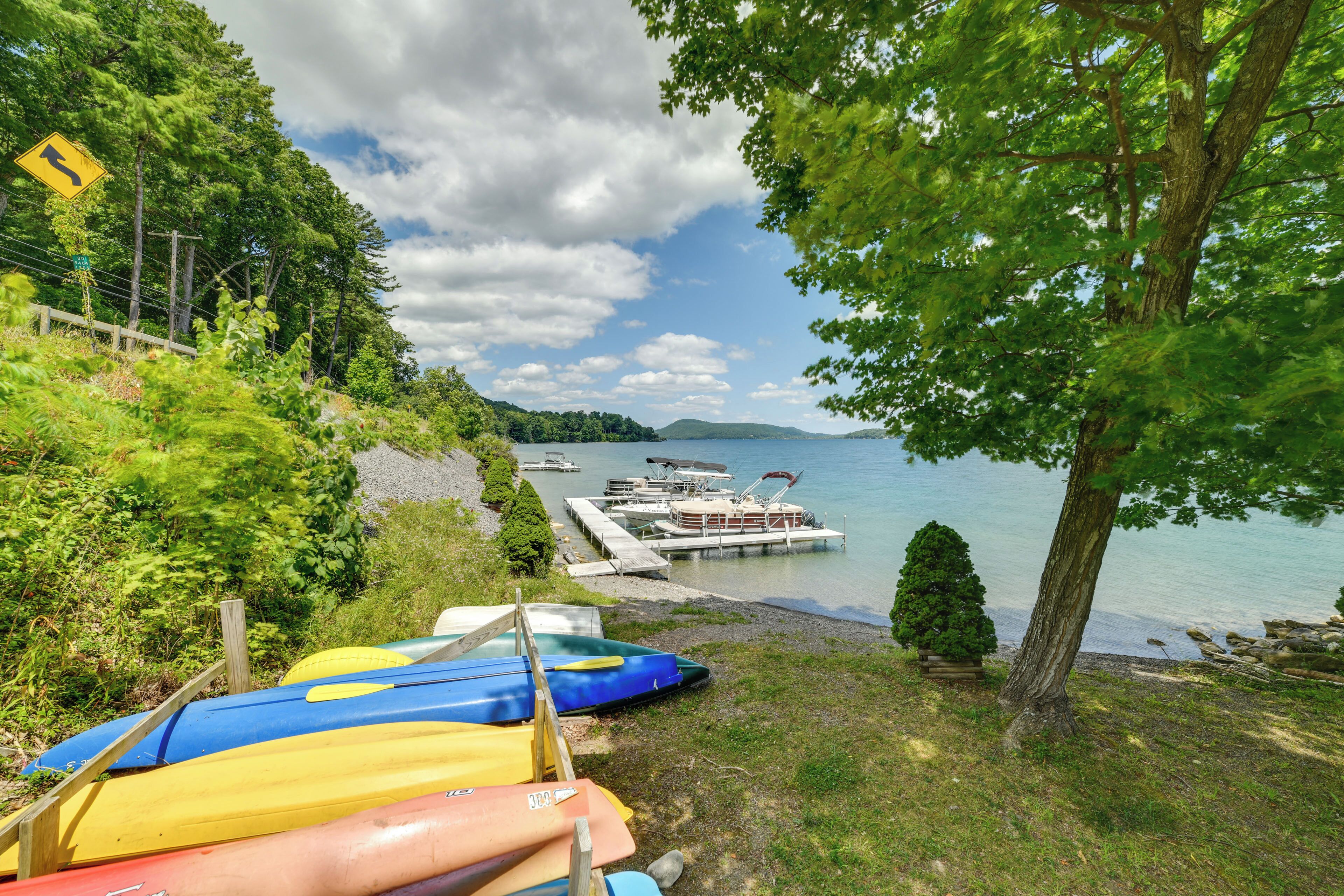 A lakeside view with canoes, a dock, and boats.