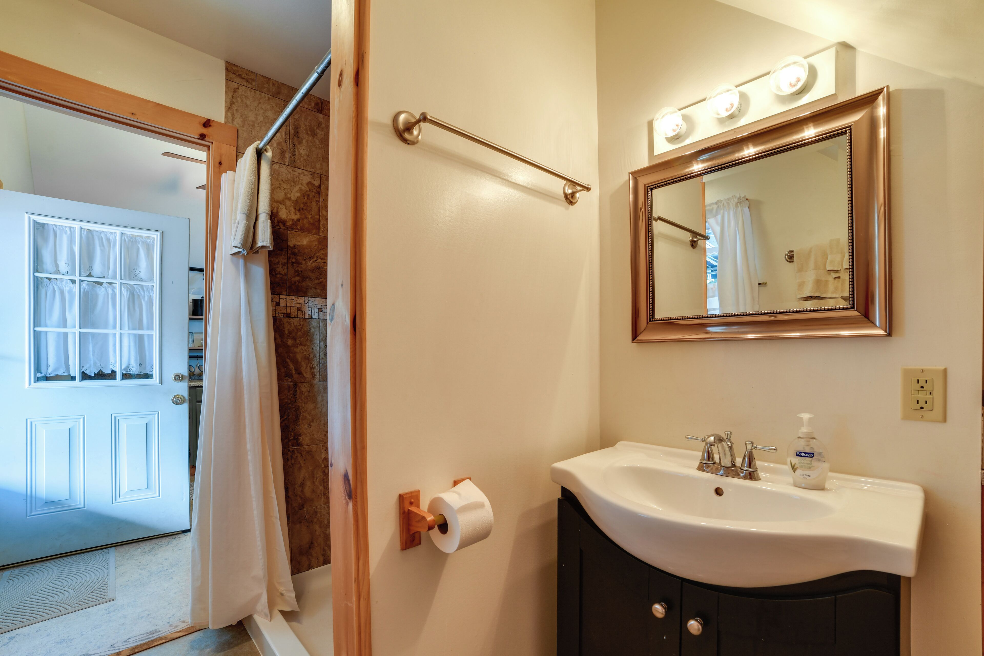 Ein Badezimmer mit Waschbecken, Spiegel und Handtuchhalter.
