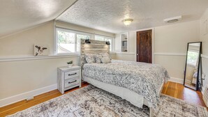 A bedroom with a bed, a nightstand, a window, and a door. - 1 Mi to Riverwalk: Home w/ Fenced Yard in Pueblo (Pueblo)