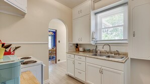 A kitchen with white cabinets, a double sink, and a window with blinds. - 1 Mi to Riverwalk: Home w/ Fenced Yard in Pueblo (Pueblo)