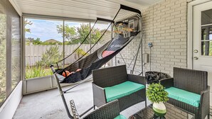 A covered patio with wicker furniture, a hammock, and a basketball hoop. - Pet-friendly Home w/ Lanais, Near Dtwn Tampa! (Seffner)