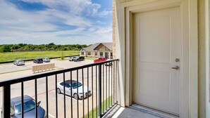A balcony with a view of a parking lot and a building across the street. - Gateway to Fort Worth & Burleson! Couples Apt (Crowley)