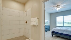 A bathroom with a shower, a bed, and a window. - Gateway to Fort Worth & Burleson! Couples Apt (Crowley)