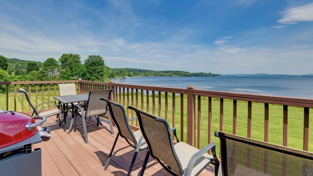 A deck with outdoor furniture overlooking a lake. - Lake Memphremagog Access: Newport Condo w/ Balcony (Newport Center)