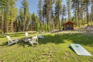 A cabin with a small deck and outdoor seating area. - Mcgregor Lake Access: Cabin in Wooded Wilderness (Marion)