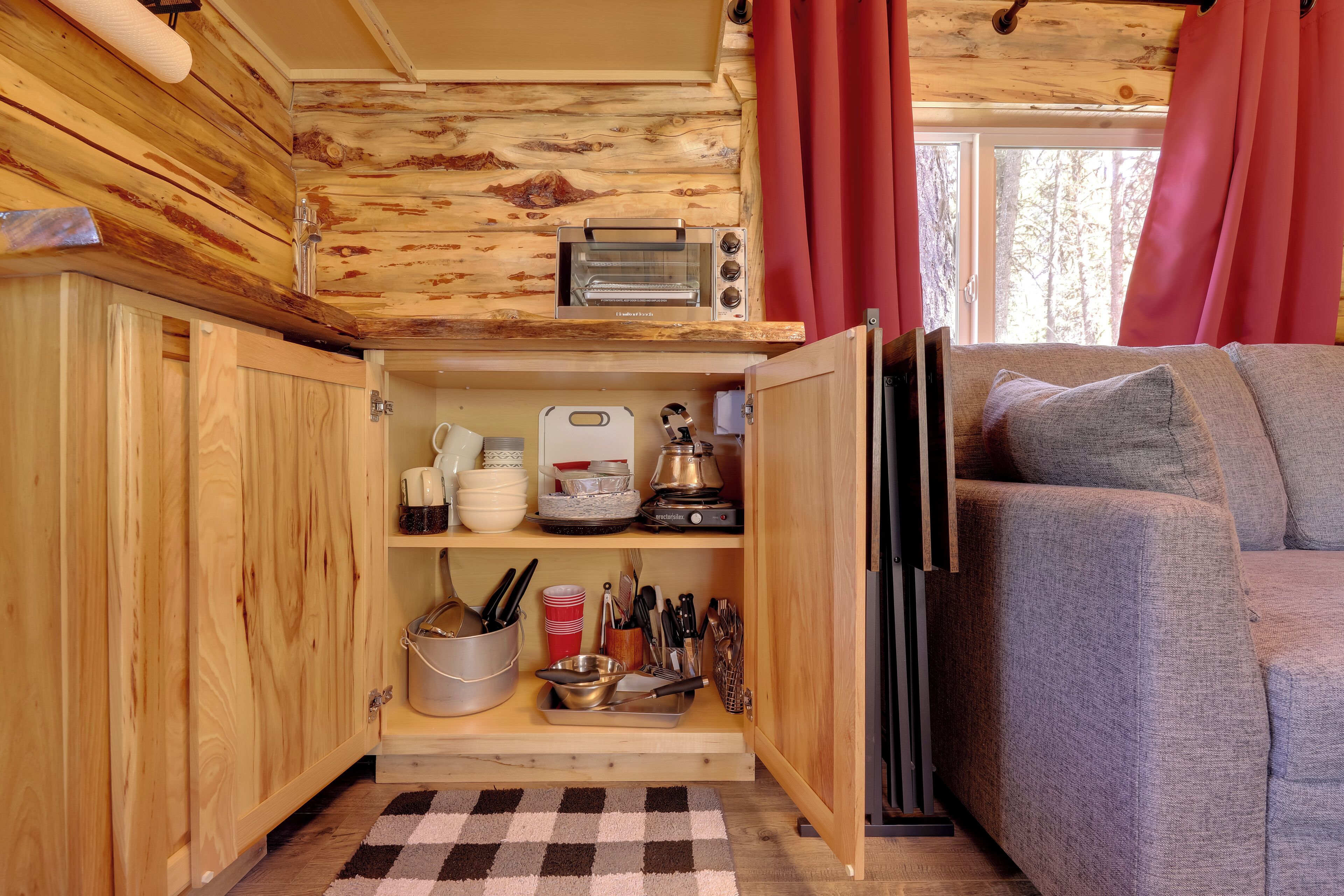 Una cucina compatta con mobili in legno, una macchina da caffè e un tostapane.