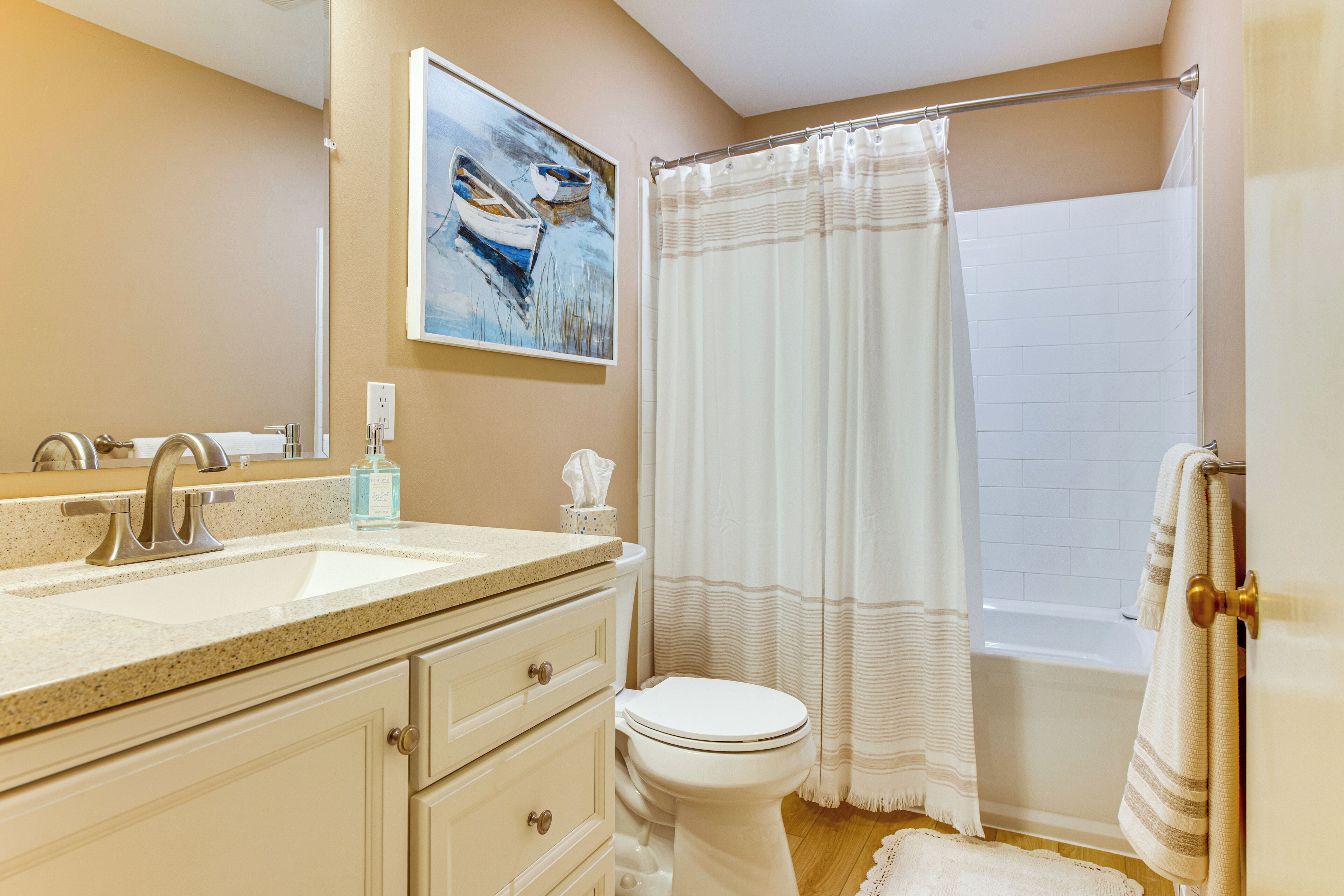 A bathroom with a sink, toilet, and bathtub.