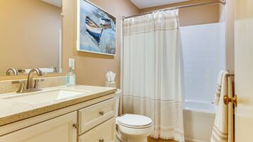 A bathroom with a sink, toilet, and bathtub.