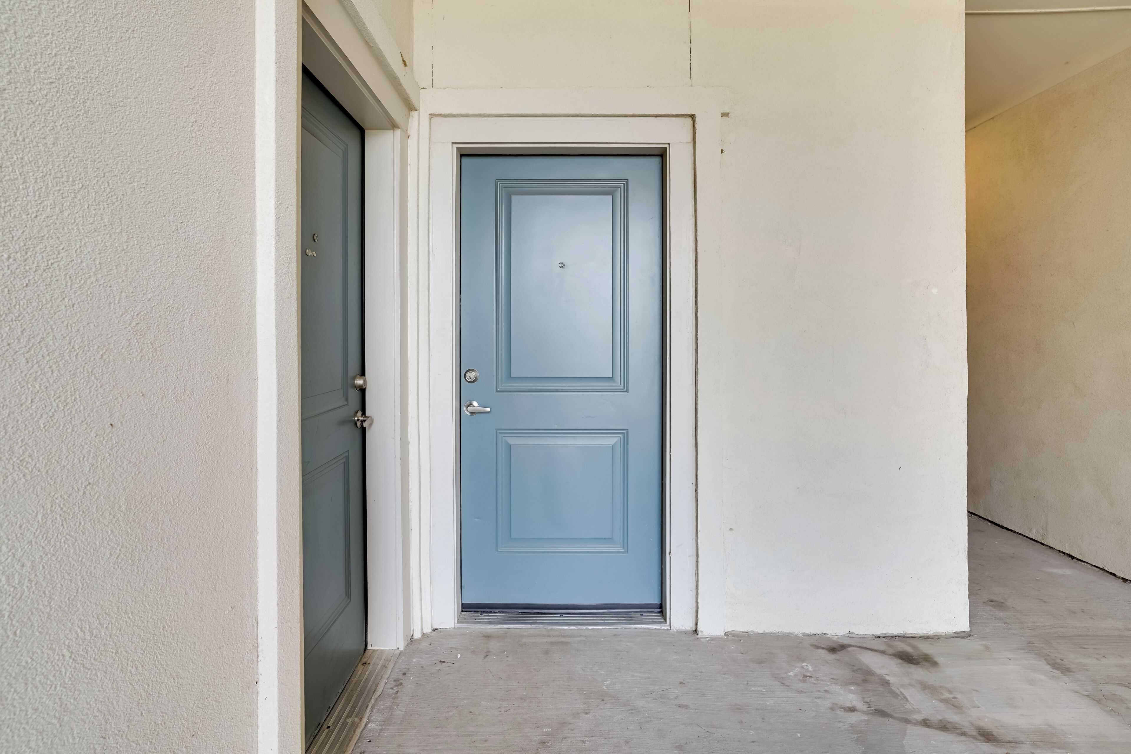 Una puerta azul cerrada, con un picaporte de metal y un pequeño ventanal en la parte superior.