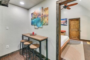 A small room with a wooden table, two stools, a ceiling fan, and a door leading to another room. - 3 Mi to Lake Texoma: Gordonville Getaway! (Gordonville)