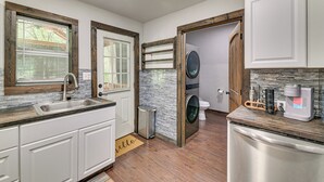 A compact kitchen with a sink, a coffee maker, and a dishwasher.