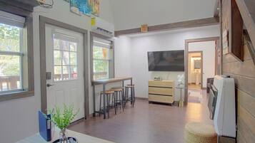 Una cocina con comedor, piso de madera y un ventanal amplio.