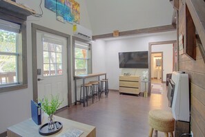Una cocina con comedor, piso de madera y un ventanal amplio.