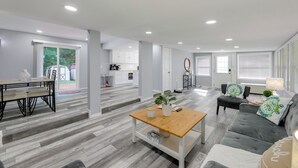 A spacious living area with a dining table, sofa, and coffee table, connected to a kitchen and a balcony. - 12 Mi to Dtwn Lewes & Beach: Delaware Home w/ Deck (Georgetown)