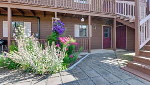 A two-story building with a balcony, a staircase, and a garden with various plants. - Community Boat Dock: Lake Memphremagog Condo! (Newport Center)