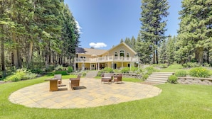 Una casa grande con un patio, rodeada de árboles.