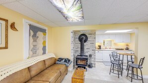 A cozy living room with a brown leather sofa, a wooden coffee table, and a fireplace. - Crystal Lake Retreat Studio: Walk to Happy's Inn! (Libby)