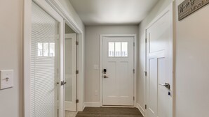 A hallway with a white door, a light switch, and a sign that reads "Home Sweet Home EST 2025". - Easy Assateague Access: Bayside Family Retreat! (Berlin)