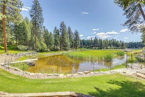 A serene outdoor setting with a pond, surrounded by lush greenery and tall trees. - Crystal Lake Retreat Apt: Walk to Happy's Inn! (Libby)