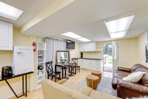 A compact living space with a kitchenette, a dining area, and a seating area with a sofa and chairs.