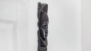 Een wandsculptuur van een menselijke figuur.