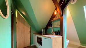 A compact kitchen with a wooden island, a built-in oven, and a hanging light fixture. - Urban hut (Sarreguemines)