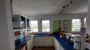 A modern kitchen with a stove, oven, sink, and a coffee maker. - Room 'Provence' with Shared Terrace and Wi-Fi (Birstein)