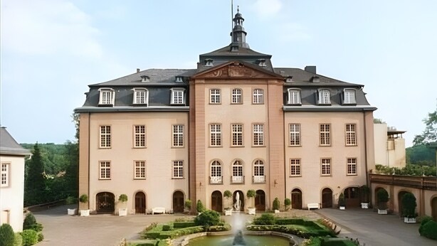 A large, symmetrical building with a central fountain, arched doorways, and a formal garden. - Room 'Provence' with Shared Terrace and Wi-Fi (Birstein)