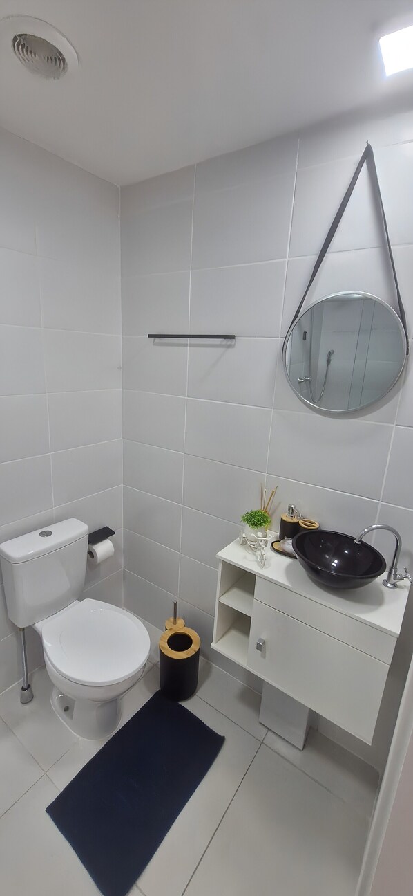 A modern bathroom with a toilet, sink, and mirror.