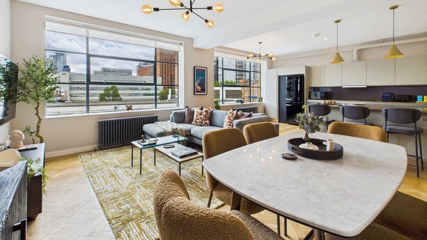 A modern apartment with a dining area, kitchen, and living room.
