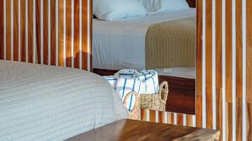 Una habitación con cama, cabecero de madera, pared tejida y lámpara colgante.