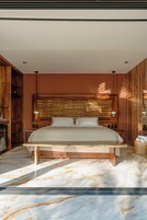Un dormitorio moderno con una cama grande, cabecera de madera, suelo de mármol y un armario de madera.