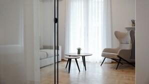A modern living room with a sofa, a round table, and a chair.
