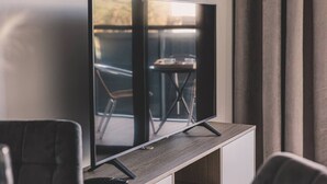 A flat-screen TV on a wooden stand in a room with a modern design.