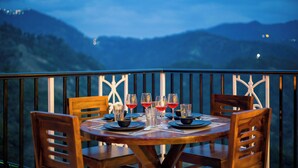 Une table dressée pour le dîner, avec une vue sur les montagnes en arrière-plan.