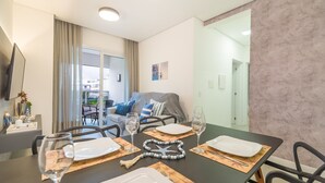 A dining area with a table set for four, two wine glasses, and a decorative item. - Apart in Cond. w/ Pool 400m From the Beach Tdb0101 (Florianópolis)