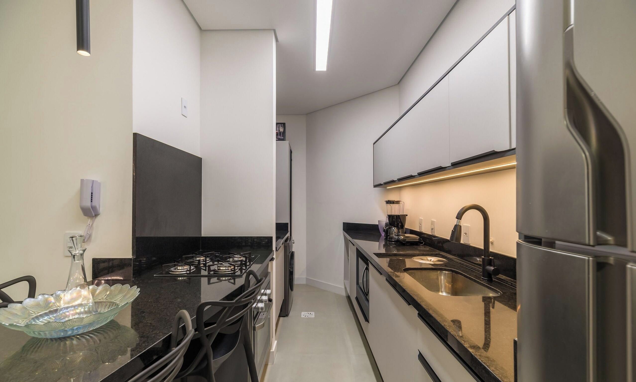 A modern kitchen with a gas stove, stainless steel appliances, and a glass bowl on the counter.