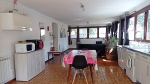 Une cuisine équipée d’une table à manger, d’un four à micro-ondes et d’un lave-linge.