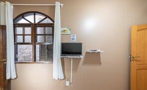 A room with a large window, a flat-screen TV, a Wi-Fi sign, and a wooden door. - Cozy House Near Ufsc - Tfl002 (Florianópolis)
