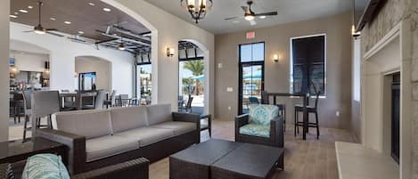 Ein großzügiger Innenbereich mit einer Sitzecke, Sesseln und einer Bar.