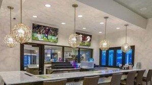 A restaurant with a long counter, wicker chairs, and hanging crystal chandeliers. - Magical Getaway Near Disney Private Pool + Resort Access, Bbq Grill! 4 Bedroom Townhouse (Kissimmee)