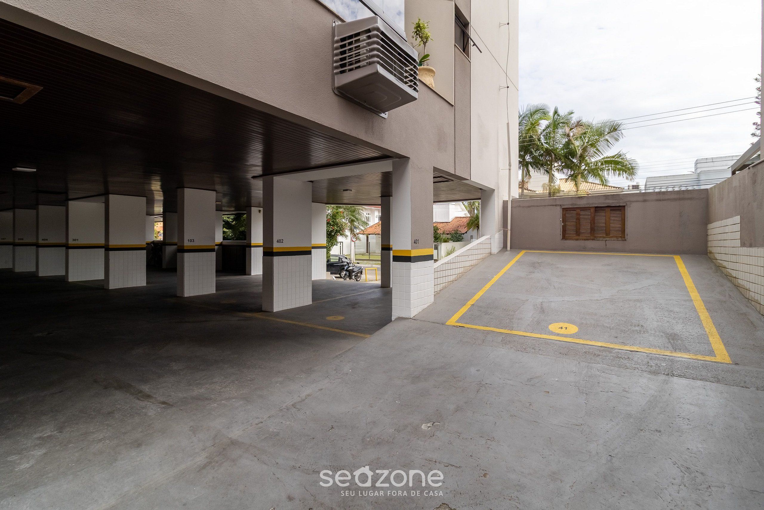 Eine Parkgarage mit nummerierten Stellplätzen und einer gelben Markierungslinie.