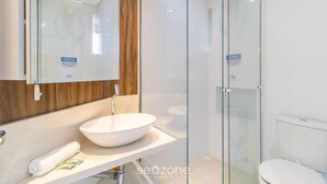 A modern bathroom with a large mirror, a white sink, and a glass shower enclosure. - Apartment 400m From Jurere Beach Cds0401 (Florianópolis)