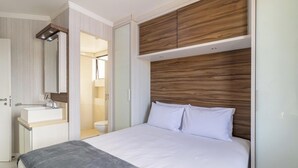 A modern bedroom with a large bed, a bedside table, a mirror, and a wooden headboard. - Apartment 400m From Jurere Beach Cds0401 (Florianópolis)