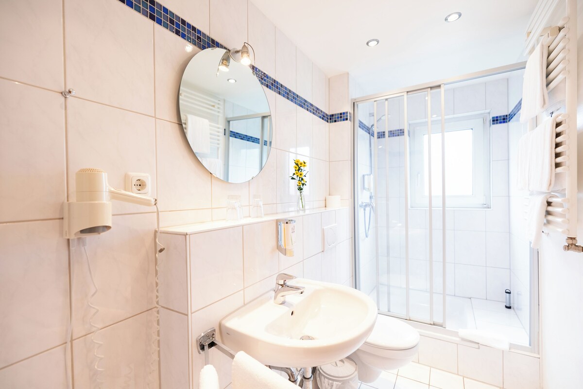 Une salle de bain moderne avec un lavabo, un miroir et une douche.