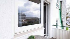 A balcony with a view of buildings and a cloudy sky. - acora Bremen Garden Living the City (Bremen)