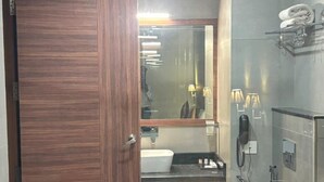 Une salle de bain moderne avec une porte en bois, un lavabo, des toilettes et une douche à parois de verre.